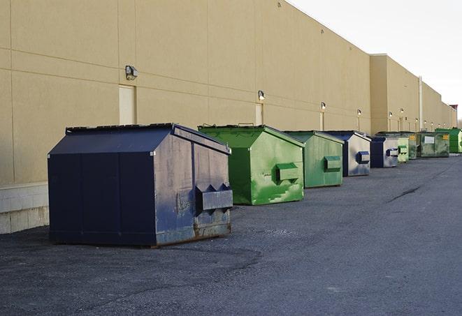 a pile of demolition waste sits beside a dumpster in a parking lot in Lauderdale-by-the-Sea FL